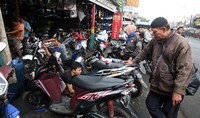 Sebuah bengkel dipadati pemilik kendaraan sepeda motor yang melakukan perawatan rutin.