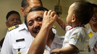 Elfien Goentoro menggendong seorang anak yang mengikuti mudik gratis.