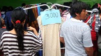 Dua orang warga memilih pakaian yang dijual Rp 3.000.