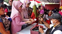 Warga membeli kupon yang akan digunakan untuk membeli sembako murah. Pool/Lamhot Aritonang/detikFoto.