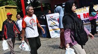 Warga meninggalkan DPP PDIP sambil menenteng sembako yang dijual murah. Pool/Lamhot Aritonang/detikFoto.