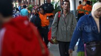Para pemudik membawa tas besar dan koper.