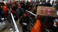 Para calon penumpang membawa barang bawaan khas mudik seperti tas besar dan kardus.