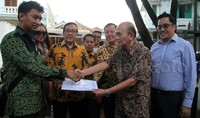 Ketua Umum Pengurus Besar Himpunan Mahasiswa Islam (HMI) Arief Rosyid Hasan (kiri) menyerahkan berita acara pengembalian aset kepada Presdir PT Rahmat Tamin (dalam likuidasi) Mustafa Gani Tamin (kanan) disaksikan Mantan Ketum PB HMI Akbar Tandjung (tengah) di Jakarta, Selasa (14/7/2015).