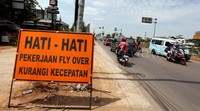Sebuah rambu peringatan berwarna orange bertuliskan : Ada pengerjaan proyek jalan, kurangi kecepatan, banyak terpasang di Kalimalang yang menghubungkan Jakarta dengan Bekasi.