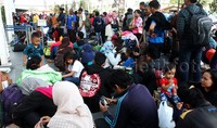 Terlihat diantara para pemudik ada yang duduk dilantai menunggu giliran masuk ke dalam peron stasiun. Pool/Lamhot Aritonang/detikcom.