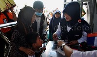 Petugas melakukan pengecekan tiket dan Kartu Tanda Pengenal saat penumpang akan memasuki peron stasiun. Pool/Lamhot Aritonang/detikcom.     