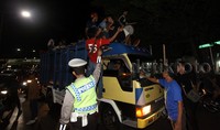 Sejumlah warga yang merayakan malam takbir dengan menaiki truk tampak mendapat teguran dari aparat kepolisian.