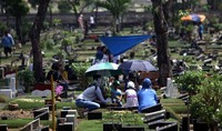 Tidak hanya mendoakan, para peziarah juga melakukan bersih-bersih makam.
