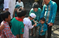 Raul Lemos dan Krisdayanti bersama putranya, Kellen, terlihat membagikan sejumlah uang pada anak-anak yang mengantri.