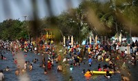 Tampak ribuan wisatawan berenang bersama keluarga dan kerabatnya di pantai Ancol.