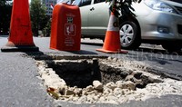 Penutup saluran air hilang menyebabkan jalan tampak berlubang cukup besar. Pool/Lamhot Aritonang/detikFoto.     
