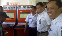 Jonan kemudian menuju dua alat mesin pencetak tiket mandiri. Dia melihat langsung proses pencetakan tiket tersebut di layar monitor.