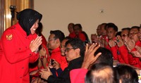 Risma yang memakai seragam PDIP kemudian menyusul di belakang lalu duduk di samping Mega. Risma memberi salam saat memasuki sekolah partai calon kepala daerah. Pool/Lamhot Aritonang/detikFoto.