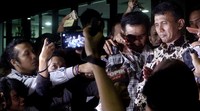 Gatot berjalan menuju mobil Innova putih untuk meninggalkan gedung KPK.