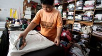 Seorang karyawan, tengah menyeterika pakaian, di tempat laundy pakaian, di Jalan Pekayon, Kota Bekasi.