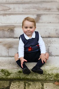 George tampak imut tersenyum di halaman Istana Kensington, Inggris di foto Natal yang dirilis pihak kerajaan. The Duke and Duchess of Cambridge/PA Wire via Getty Images/detikFoto.