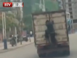 Beraksi ala Bintang Film, Seorang Bocah Gelantungan di Pintu Truk