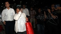 Aryani meninggalkan gedung KPK sambil menutupi wajahnya.