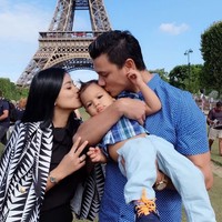 Titi dan Tian mengecup buah hati mereka, Juna. (Instagram/titi_kamall)