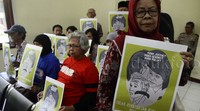 Massa membawa poster menolak pembebasan bersyarat Pollycarpus.