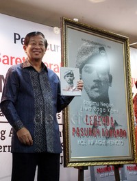 Agum Gumelar memegang buku berjudul 'Bagimu Negeri, Jiwa Raga Kami' di sela acara peluncuran.