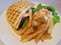 Waffle Burger berisi waffle gurih dengan cocktail sauce, telur mata sapi, beef bacon, beef patty dan selada. Pendamping berupa kentang goreng padat renyah dan American coleslaw.