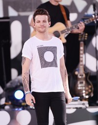 Kenakan kaus putih dipadu celana panjang hitam, Louis Tomlinson terlihat kasual. Stephen Lovekin/Getty Images/detikFoto.
