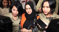 Evy keluar dengan memakai rompi tahanan KPK.