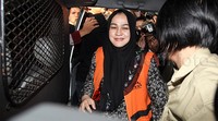 Evy sempat menebar senyum saat memasuki mobil tahanan KPK.