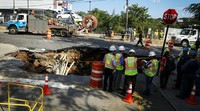 Kemunculan lubang besar ini menghancurkan aspal di perempatan jalan Fifth Avenue dan 64 Street. Lubang ini juga memutus saluran pipa bawah tanah yang cukup vital. Kena Betancur/AFP/detikFoto.