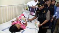 Petugas KPAI memberikan bingkisan kepada seorang pasien.