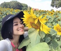 Ia tampak sangat menikmati keindahan bunga matahari. (Instagram/titi_kamall)