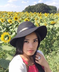Kenakan floppy hat, Titi tak lupa selfie di kebun bunga matahari. (Instagram/titi_kamall)