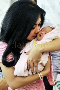 Syahrini menggendong dan mengecup keponakannya. Pool/Noel/detikFoto.