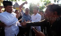 Sedangkan di dada kiri keduanya terdapat pin bergambar foto Rasiyo-Dhimam Abror.     