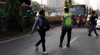 Aparat kepolisian menyetop kendaraan bermotor saat para penumpang yang turun di pinggir tol menyeberang. Pool/Lamhot Aritonang/detikFoto.
