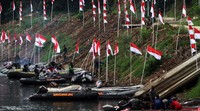 Prajurit dari Kodam Jaya mengibarkan bendera merah putih di pinggir Kali Ciliwung.