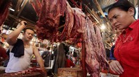 Pedagang memotong daging sapi menjadi bagian yang lebih kecil.