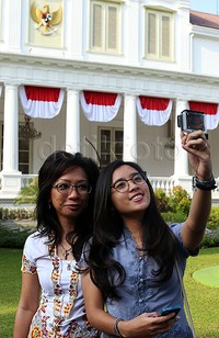 Dua orang tamu selfie di depan Istana Negara sebelum upacara HUT ke-70 RI.