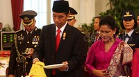 Jokowi memotong tumpeng.
