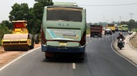 Alat berat melakukan pelebaran jalan.