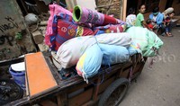 Sebagian warga Kampung Pulo melakukan evakuasi harta benda meraka, Kamis (20/08/2015).     