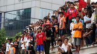 Warga menonton dari kejauhan.