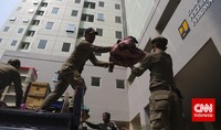 Dalam pross pemindahan barang-barang tampak dibantu oleh anggota Satpol PP. Pool/Adhi Wicaksono/CNNIndonesia.     