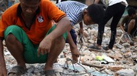Seorang anak mengumpulkan besi-besi di lokasi penggusuran.