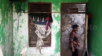 Seorang warga melintas di depan rumah yang akan dibongkar.
