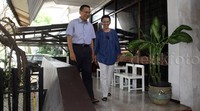 Cat putih di temboknya kusam. Bahkan langit-langitnya sebagian terkelupas termakan usia. Kelebihannya hanya ada pepohonan rimbun yang membuat teduh dan sejuk. Selebihnya, rumah dua lantai ini hanya terlihat sebagai rumah biasa tanpa kesan.