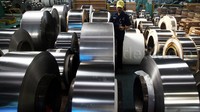 Seorang pekerja mengecek stainless steel strip.