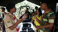 Seorang anggota TNI AD memberikan penjelasan tentang pistol kepada pramuka.